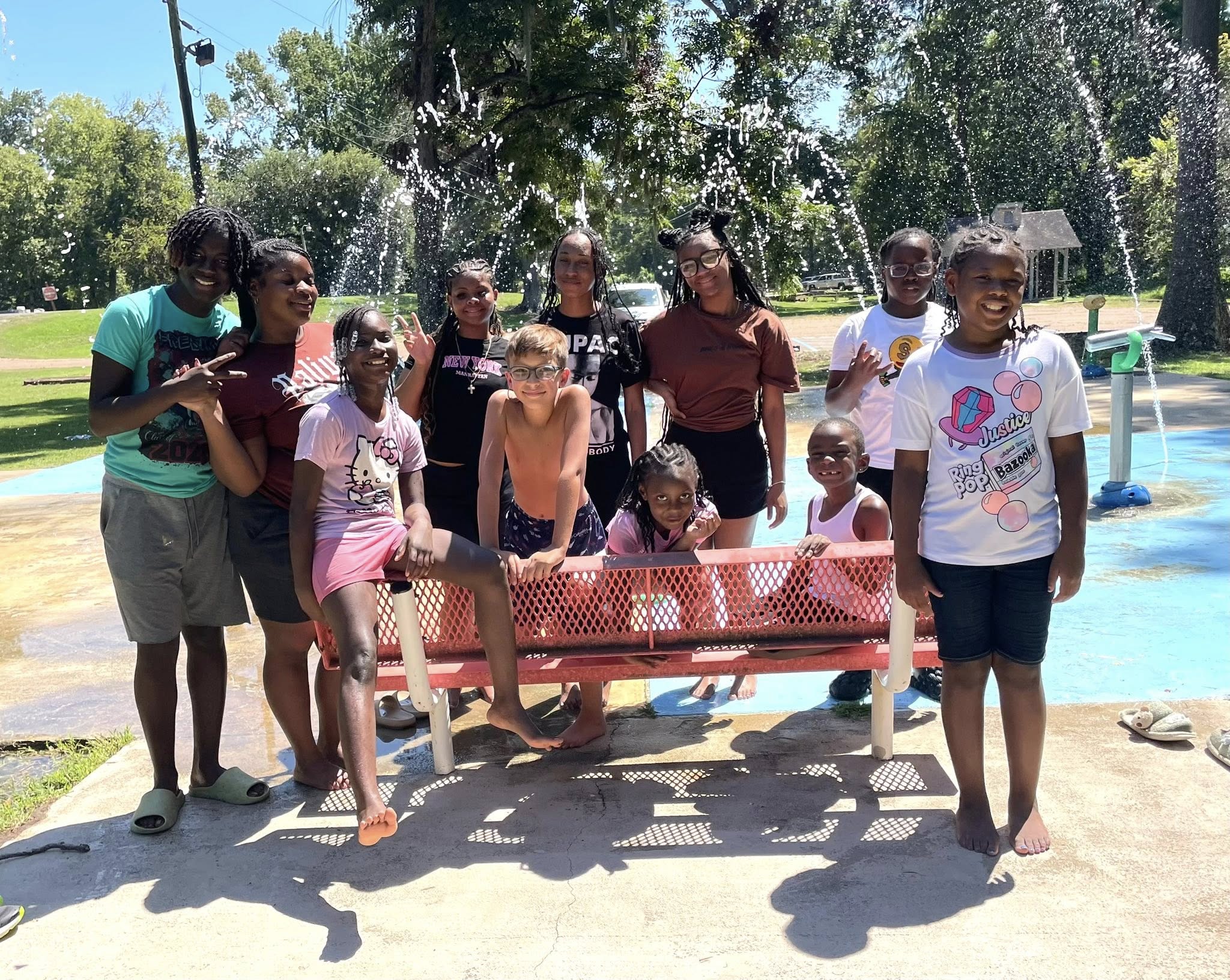A group of kids posing in front of a splash pad.